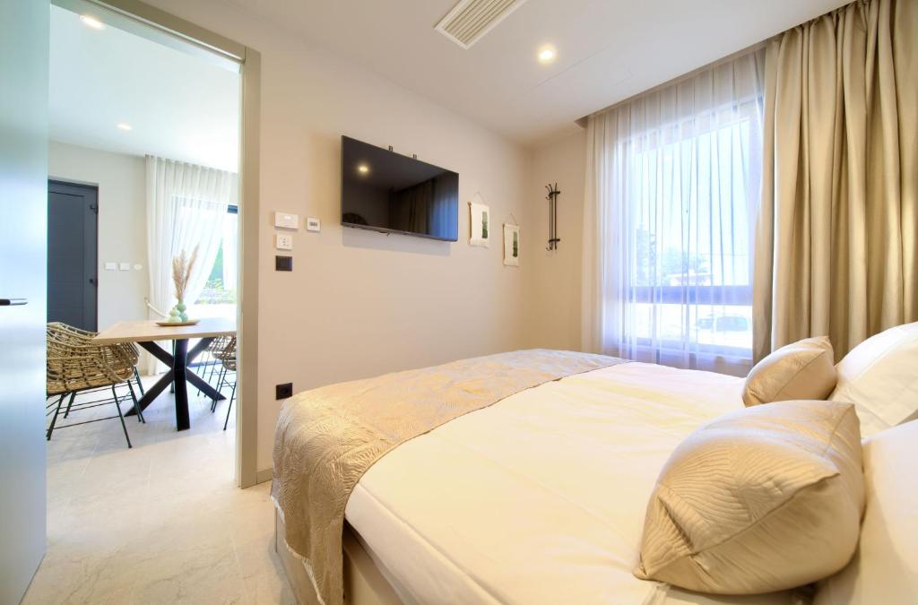 sypialnia z łóżkiem, telewizorem i stołem w obiekcie Villa QUARNARO with heated pool w mieście Omišalj
