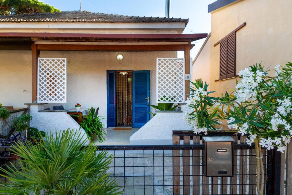 a house with a blue door and a fence at Perla marina in Grosseto