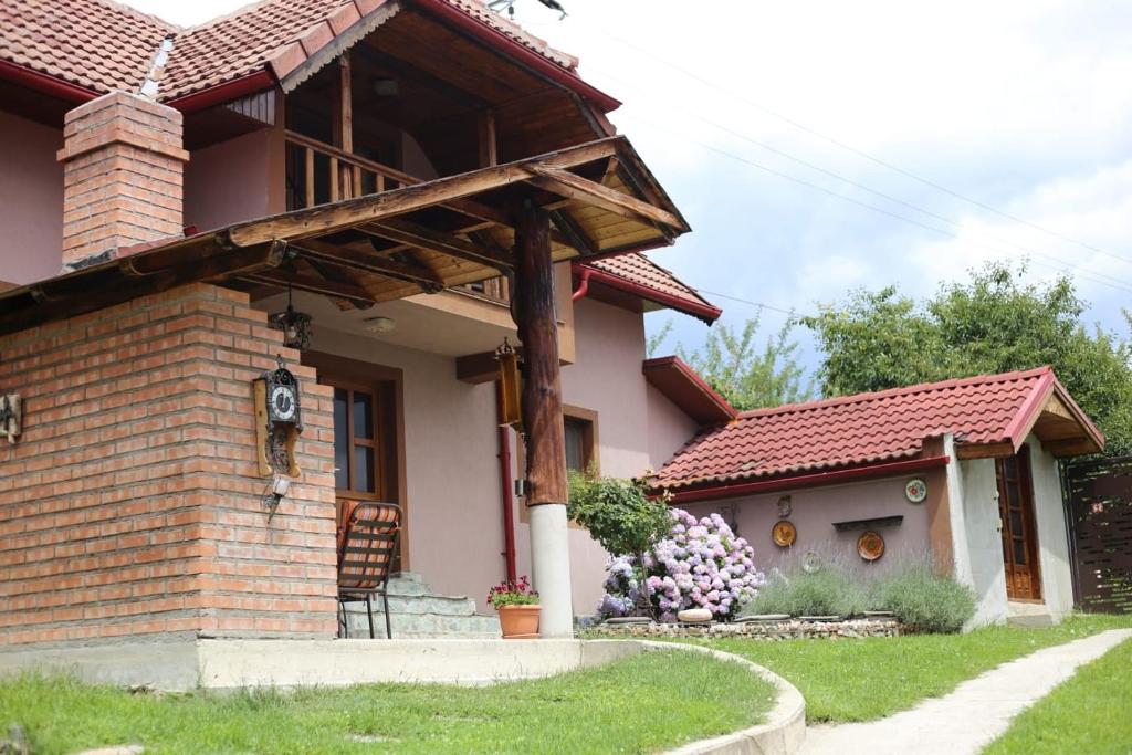a home with a brick house with a roof at Casa Darius in Novaci-Străini