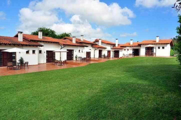 a building with a green lawn in front of it at Apartamento familiar cercano a playa de Rodiles. 3 in Villaviciosa