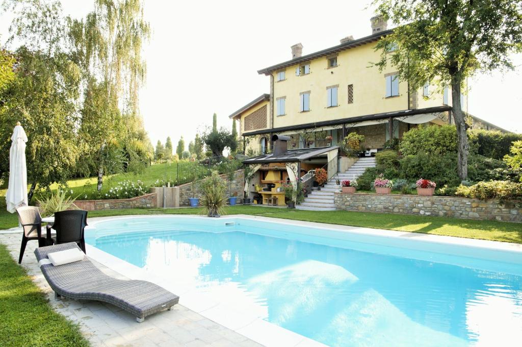 a swimming pool in front of a house at La Vedetta Bed and Breakfast in Castelvetro di Modena