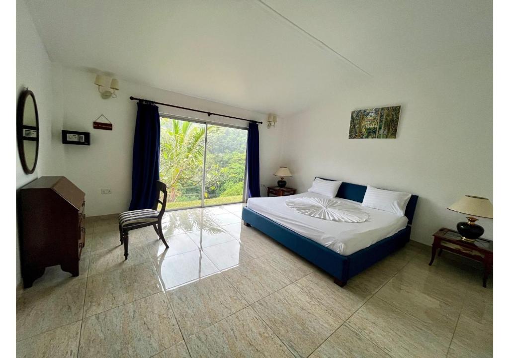 a bedroom with a bed and a chair and a window at Holiday Home in Baie Lazare Mahé