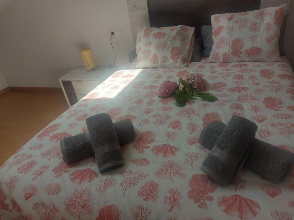 Una cama con tres almohadas de punto. en APARTAMENTO BRICIA 6, en Posada de Llanes