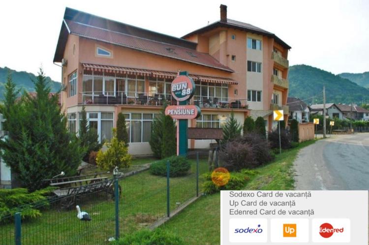 a sign in front of a building with a restaurant at Pensiunea Bun'88 in Corbeni