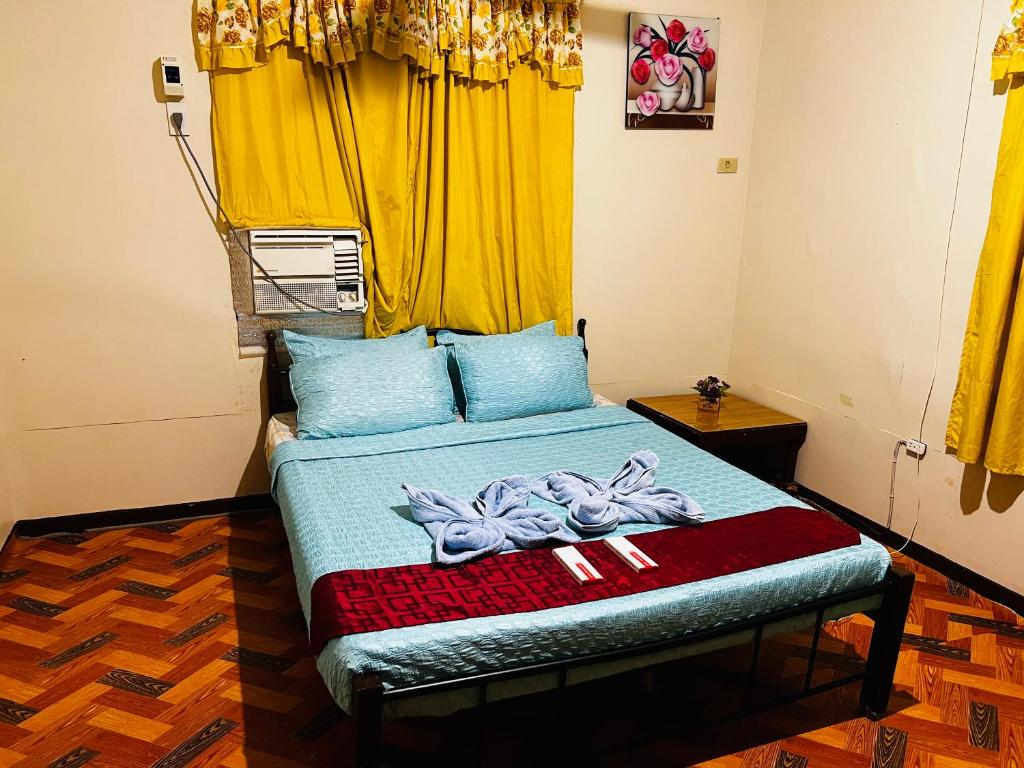 May’s Homestay في مدينة سيبو: غرفة نوم بسرير وستارة صفراء