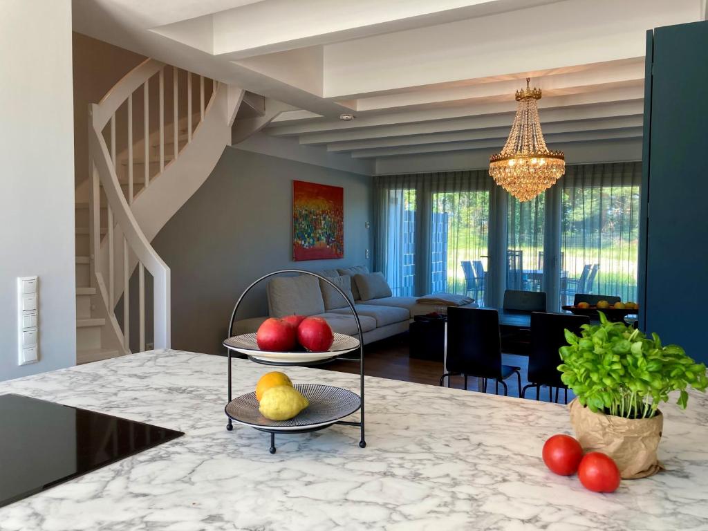 eine Küche und ein Wohnzimmer mit einem Tisch und Obst darauf in der Unterkunft Luxus-Maisonette für die große Familie mit direktem Strandzugang in Binz