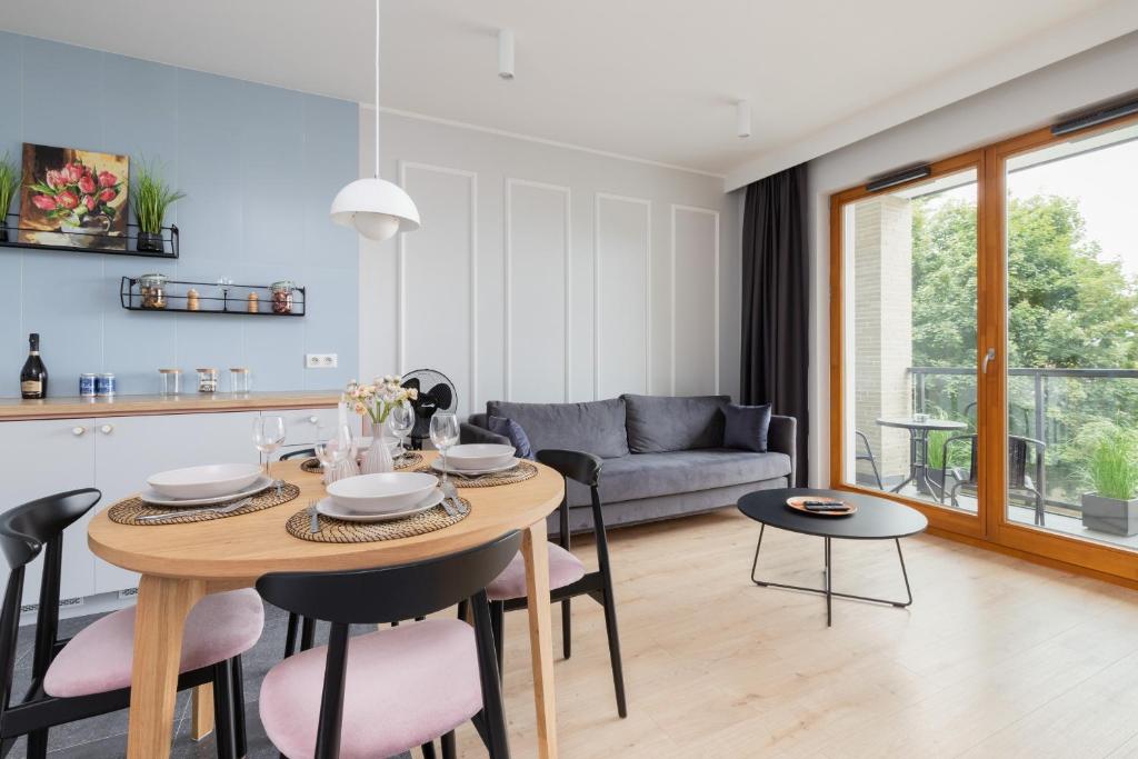 a kitchen and living room with a table and chairs at Zajezdnia Wrzeszcz Gdańsk by Renters Prestige in Gdańsk