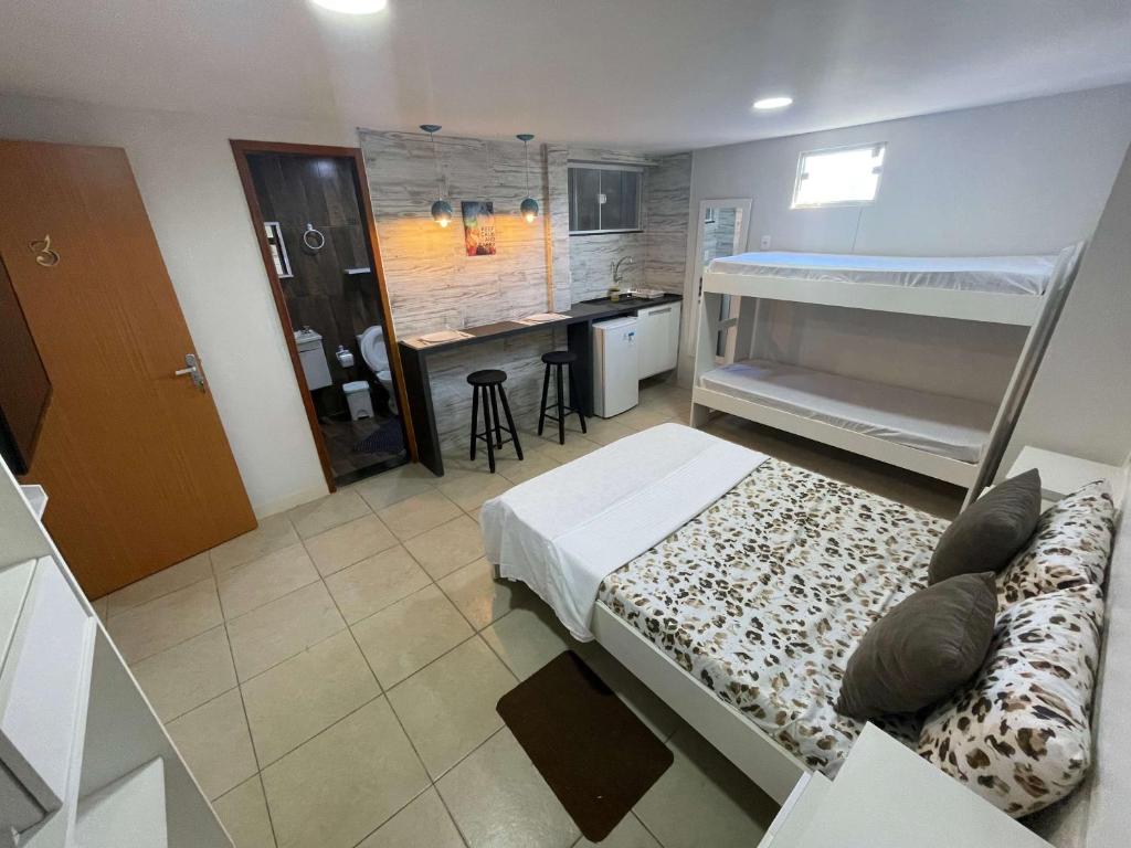 a bedroom with a bed and a kitchen with a sink at Central Praias Suíte 3 in Cabo Frio