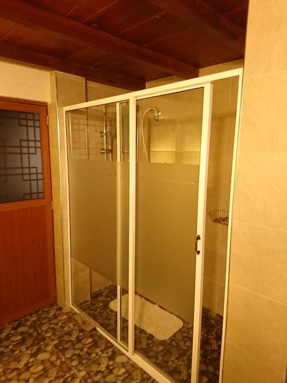 a walk in shower with glass doors in a room at Kaba Saradiel in Mawanella