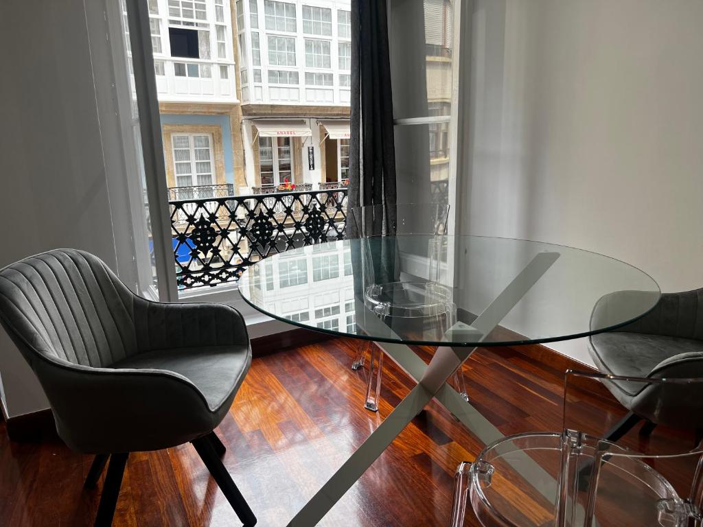 ア・コルーニャにあるOktheway Riego de Aguaの窓付きの客室で、ガラスのテーブルと椅子が備わります。