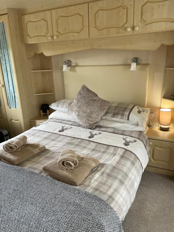 uma cama com duas toalhas em cima em Caravan at Charleston House em Inverness