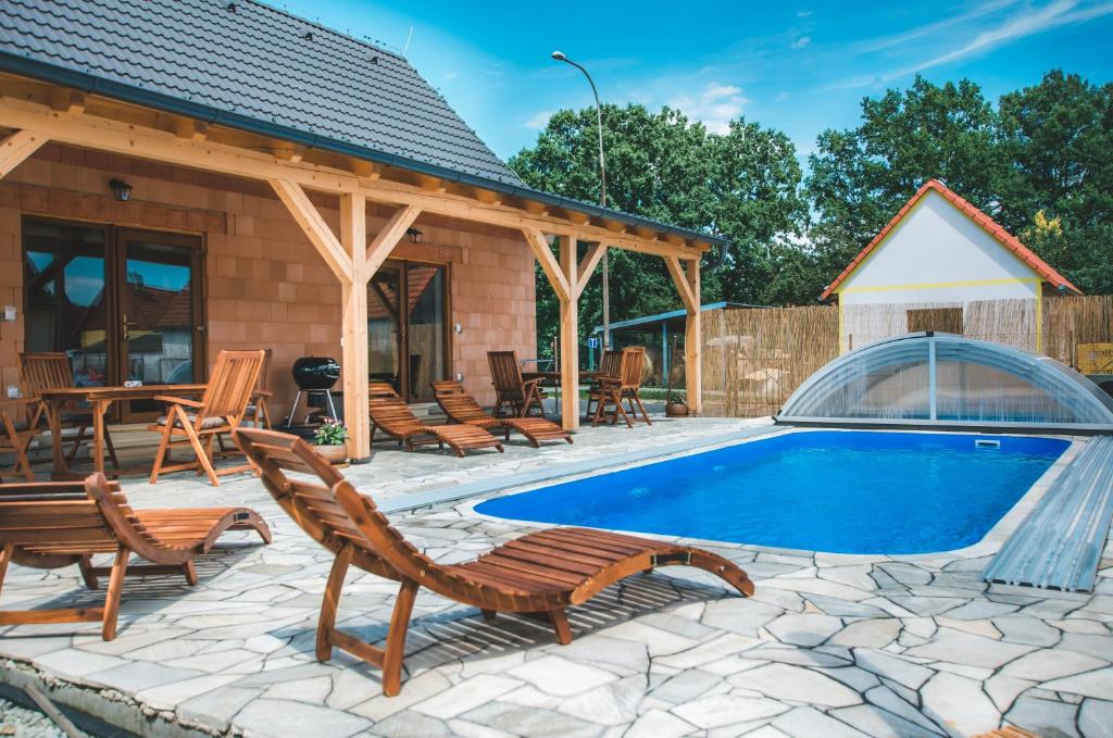 una casa y un patio con piscina y sillas en Apartmány u Kameníka - Třeboň, en Třeboň