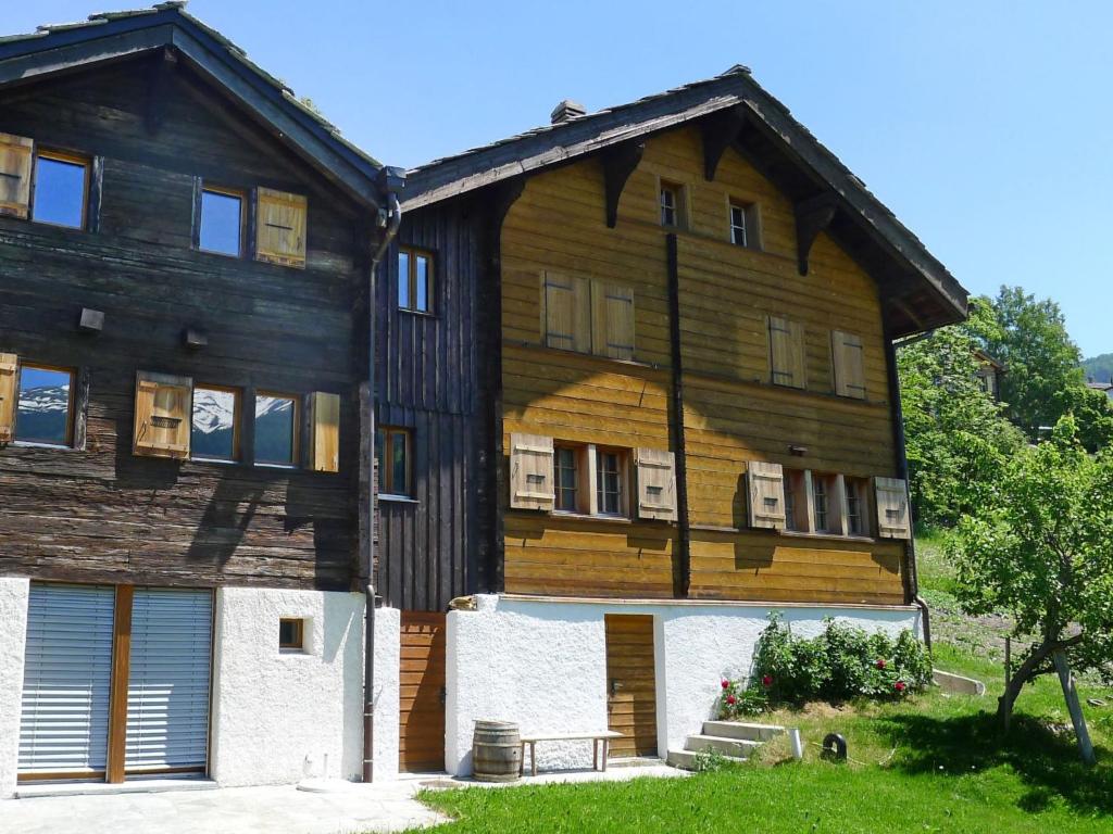 ein großes Holzgebäude mit einem Gambrel in der Unterkunft Apartment Jostbiel by Interhome in Bürchen