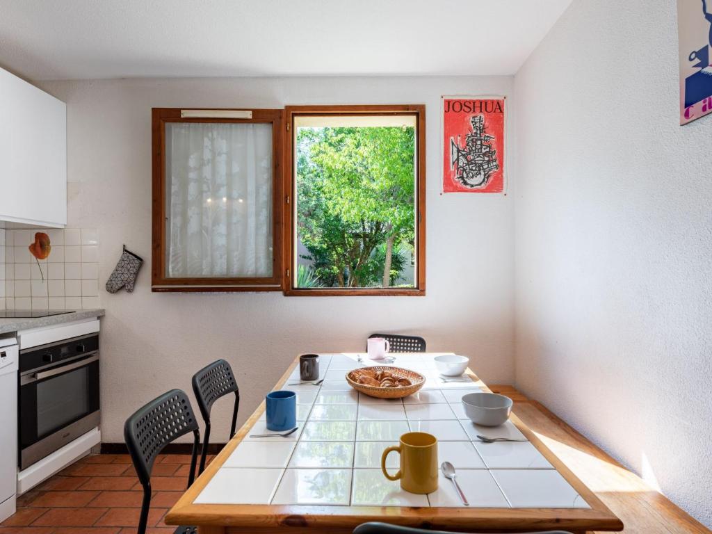 une cuisine avec une table et des chaises ainsi qu'une fenêtre dans l'établissement Holiday Home Les Landaises-9 by Interhome, à Lacanau-Océan