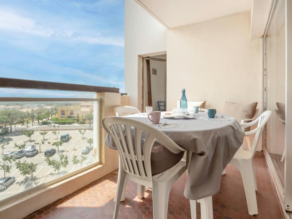 a dining room with a table and a large window at Apartment Soleil Levant 1 et 2-2 by Interhome in Le Barcarès