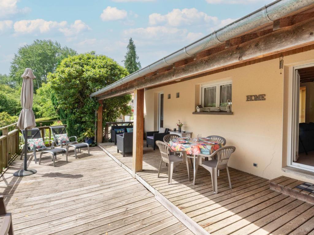 une terrasse avec une table, des chaises et un parasol dans l'établissement Holiday Home de Beaumont by Interhome, à Carentan
