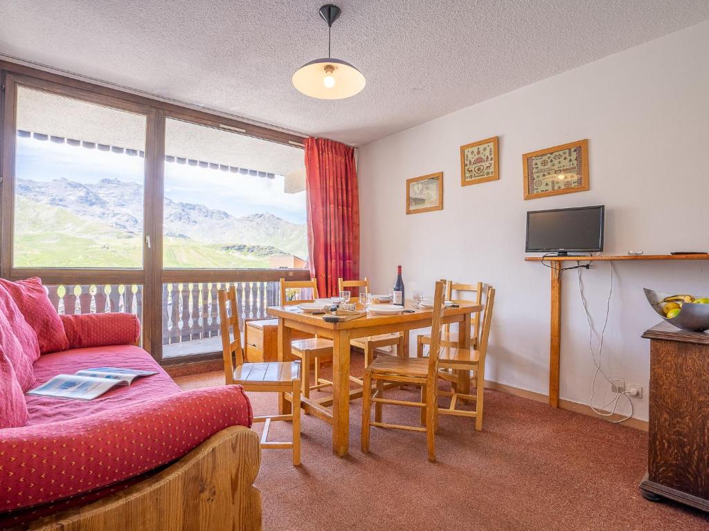 un salon avec un canapé et une table avec des chaises dans l'établissement Apartment Lac du Lou 506 by Interhome, à Val Thorens