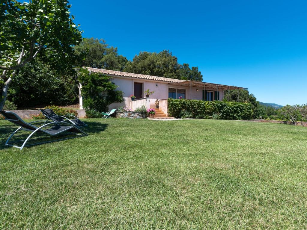 een tuin met een huis en een stoel erin bij Holiday Home Maison Christian by Interhome in Cervione