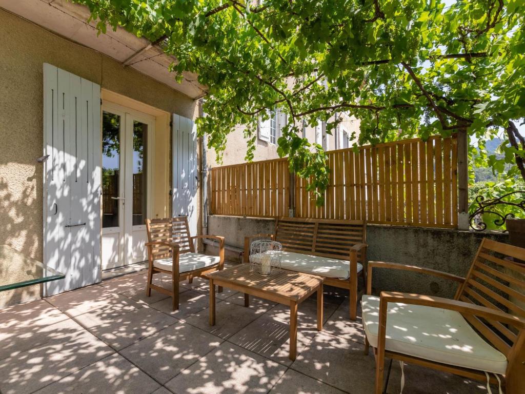 une terrasse avec 2 chaises, une table et des bancs dans l'établissement Apartment La Terrasse des Vignes - NYS180 by Interhome, à Nyons