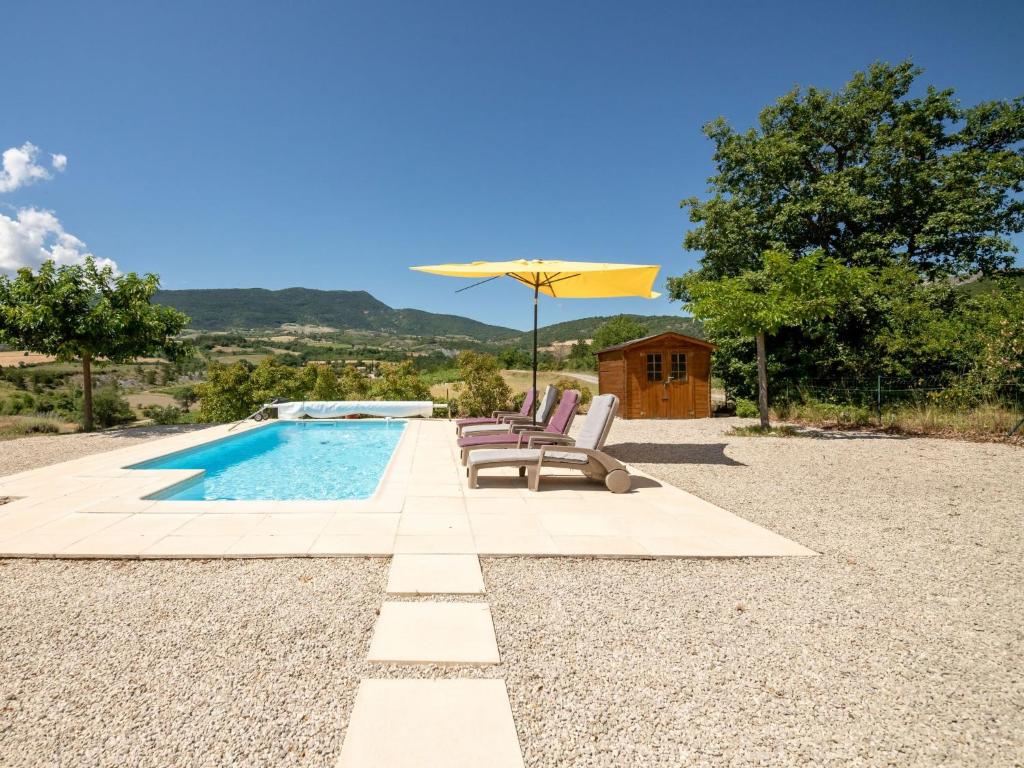 een zwembad met 2 ligstoelen en een parasol bij Holiday Home Les Hauts de Jallia - NYS130 by Interhome in Sainte-Jalle