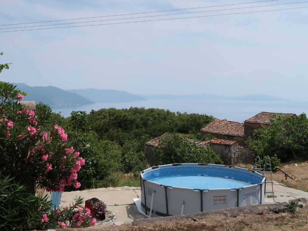 a pool in a garden with a view of the ocean at Apartment Fonović - MOD115 by Interhome in Plomin