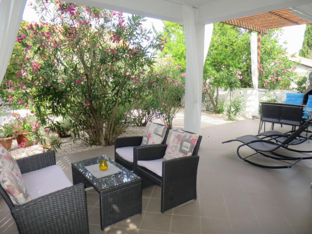 a patio with chairs and tables and a tree at Holiday Home Katarina - SRD330 by Interhome in Rovanjska