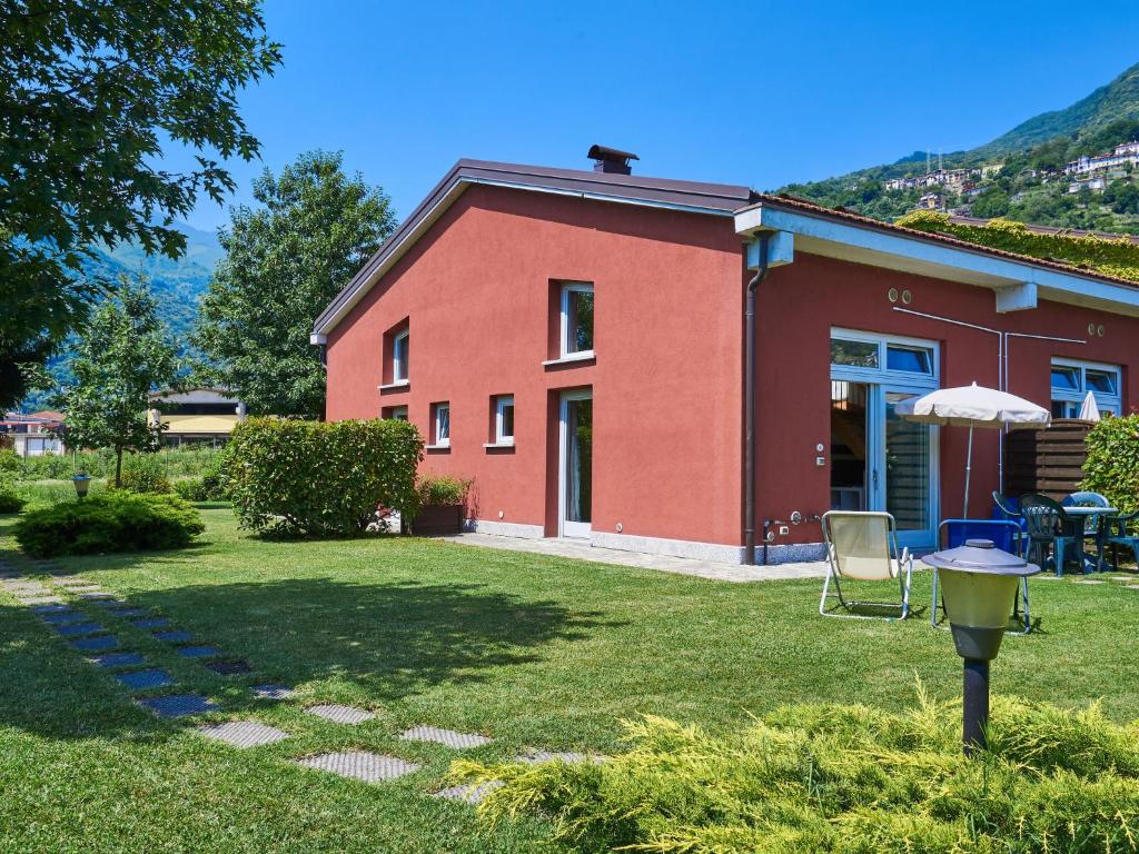 een rood huis met een grill in de tuin bij Holiday Home Gelsomino by Interhome in Consiglio di Rumo
