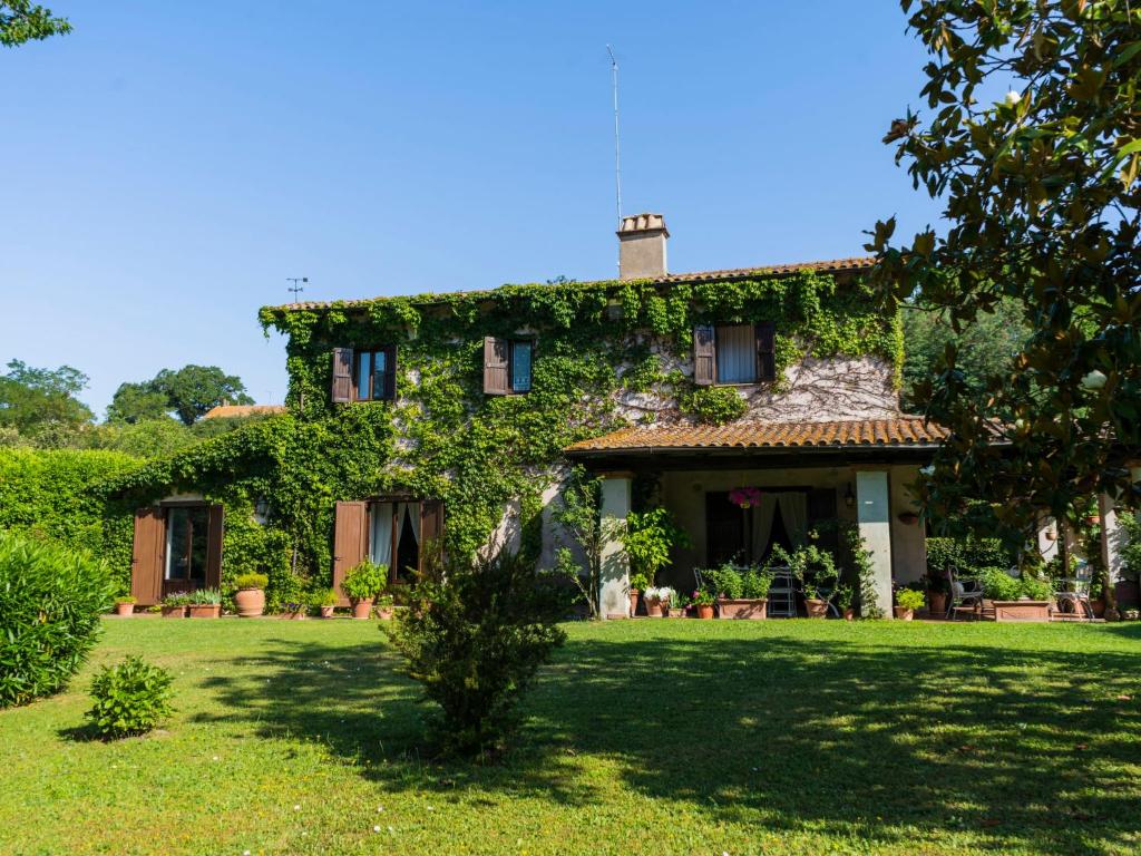 une ancienne maison recouverte de lierre sur une pelouse dans l'établissement Holiday Home Le Querce by Interhome, à Fabrica di Roma