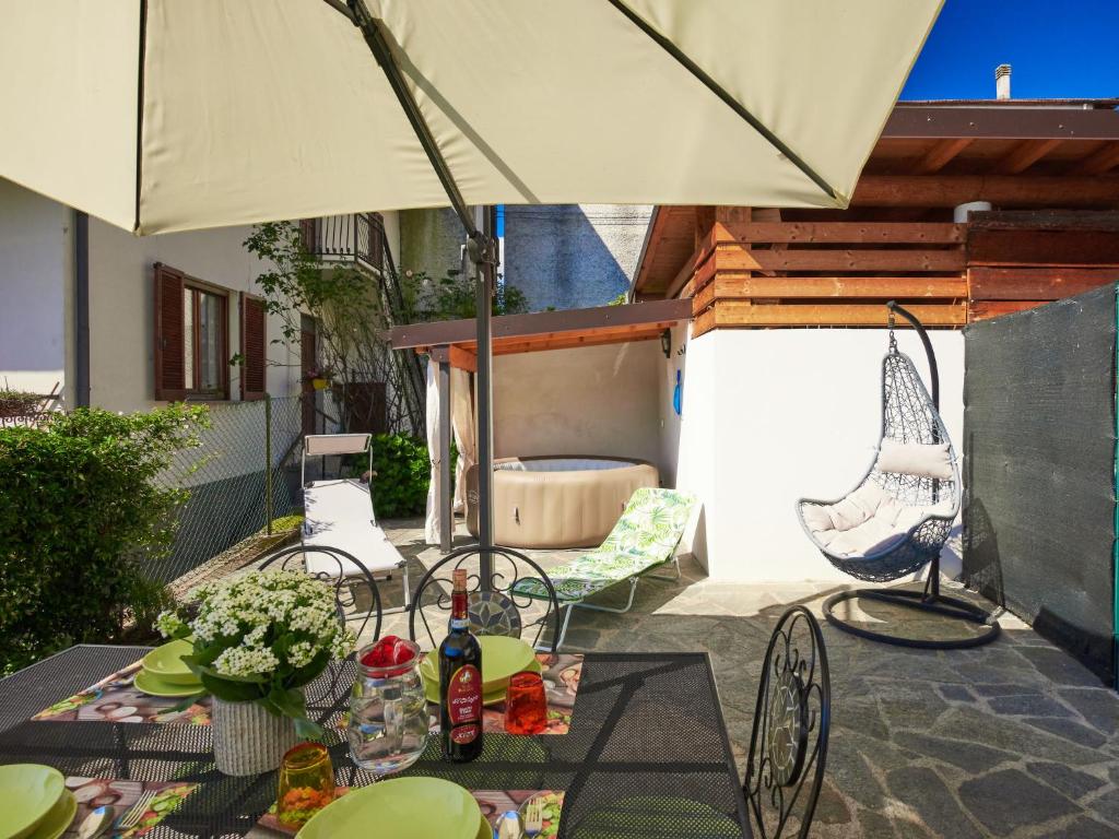 un patio con mesa y sombrilla en Apartment Livo - GRV556 by Interhome, en Livo