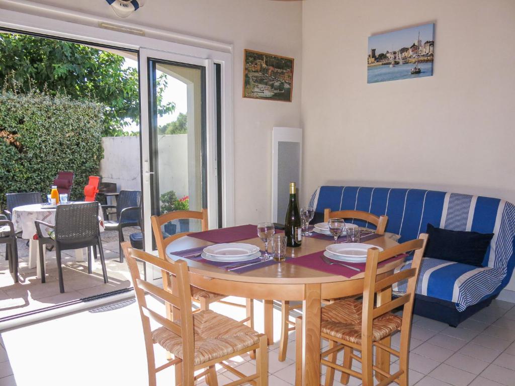 une salle à manger avec une table, des chaises et un canapé dans l'établissement Holiday Home Le Goeland Argenté by Interhome, à Les Sables-dʼOlonne