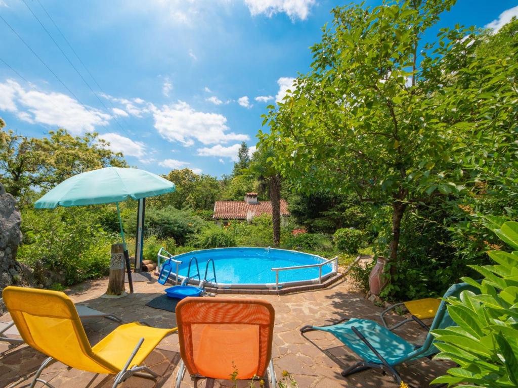a group of chairs and an umbrella next to a pool at Holiday Home Villa Hofbauer by Interhome in Dobreć