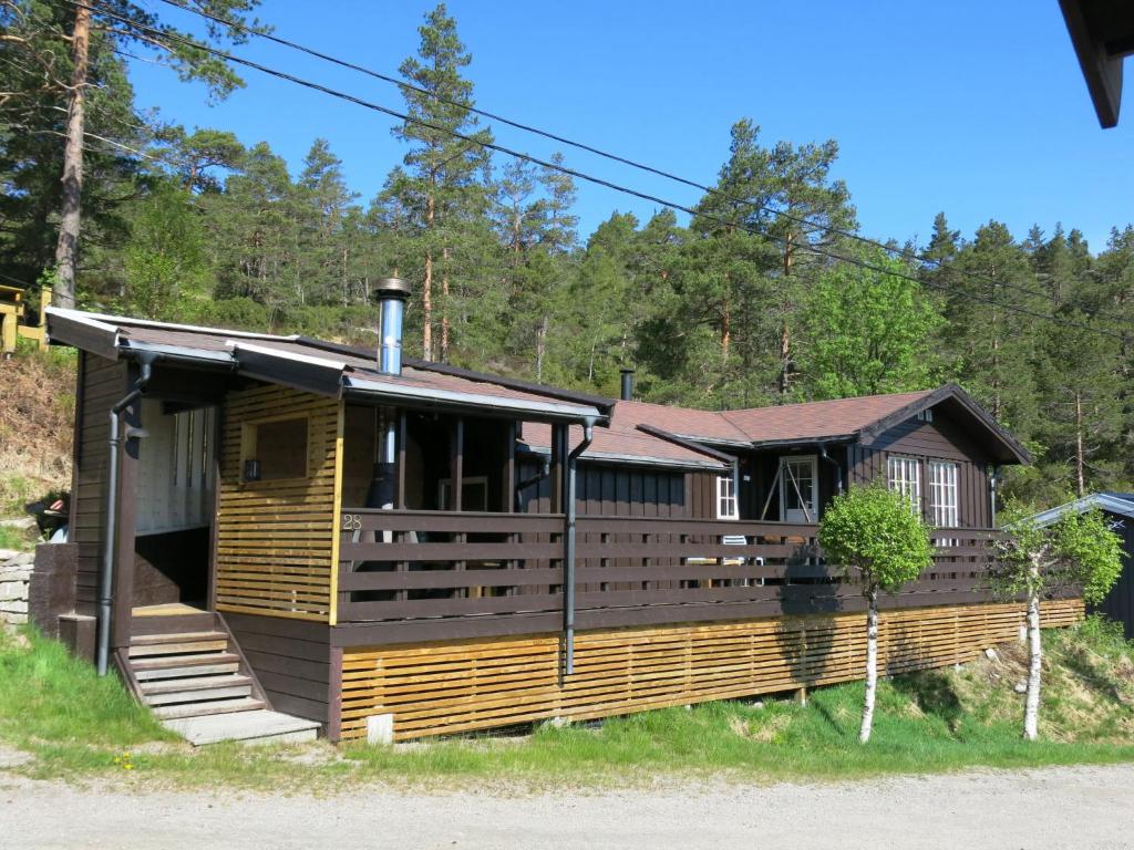 um chalé de madeira com um alpendre e escadas para ele em Chalet Bakketoppen - SOW111 by Interhome em Øyuvstad