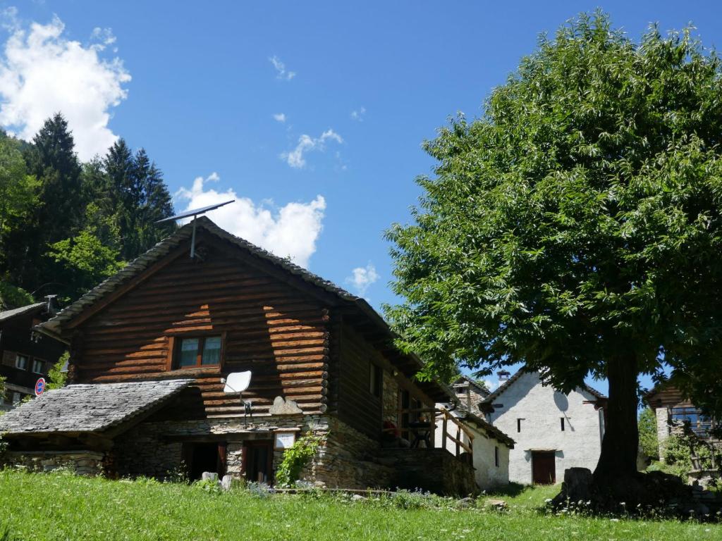 uma casa de madeira com um moinho de vento em cima em Holiday Home Rustico Ingrid - MVA338 by Interhome em Semione