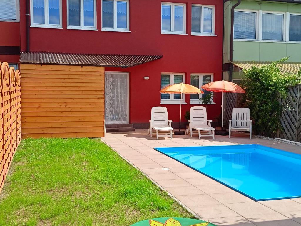 ein Haus mit einem Pool, Stühlen und Sonnenschirmen in der Unterkunft Holiday Home Olešná by Interhome in Olešná