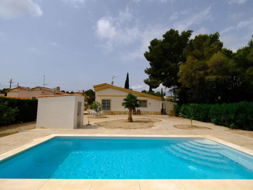 une piscine bleue en face d'une maison dans l'établissement Villa Villa Palma by Interhome, à Les tres Cales