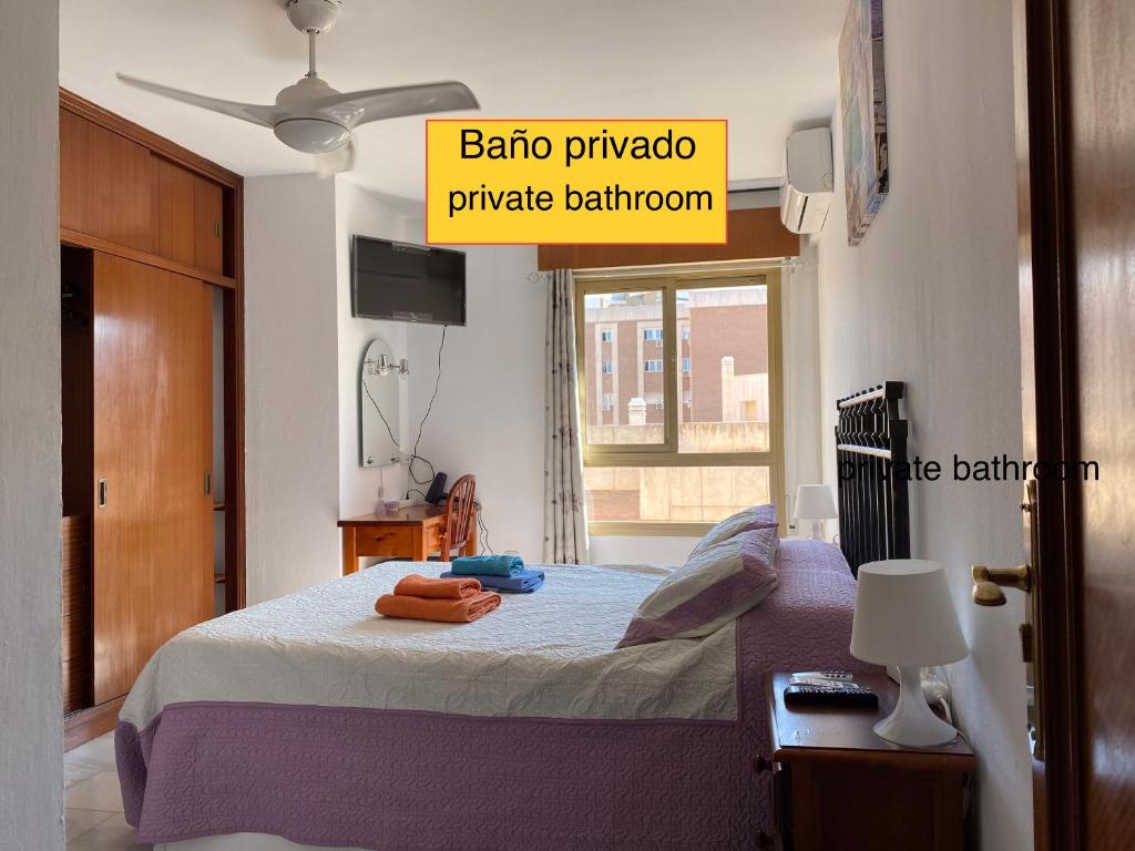 1 dormitorio con 1 cama con 2 toallas en Málaga Centro habitaciones privada en apartamento compartidos, en Málaga