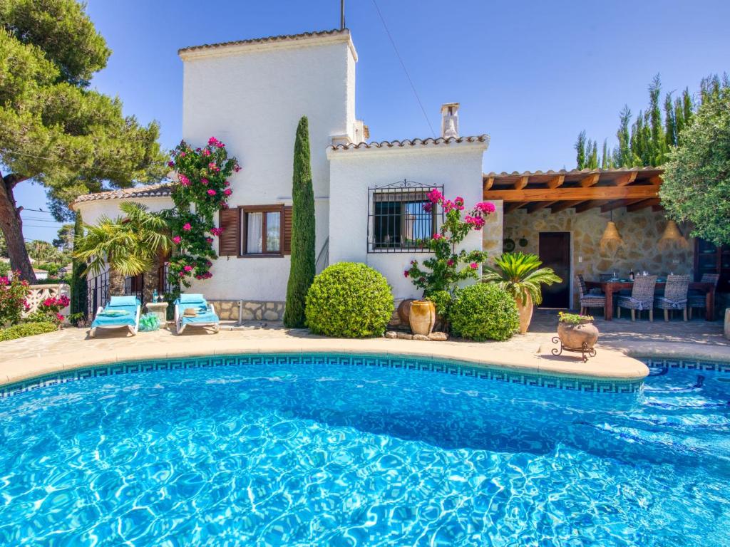 a villa with a swimming pool in front of a house at Holiday Home Mabrouk by Interhome in Jávea