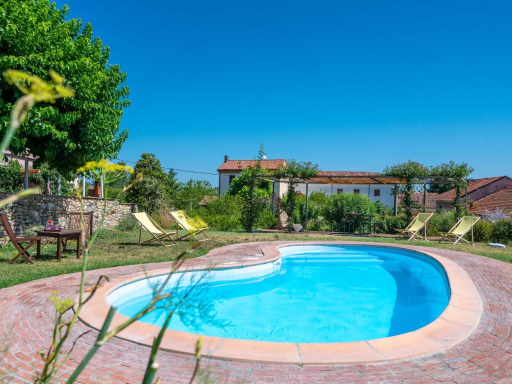 a swimming pool in a yard with chairs and a house at Holiday Home Palazzo Mariscotti by Interhome in SantʼAndrea
