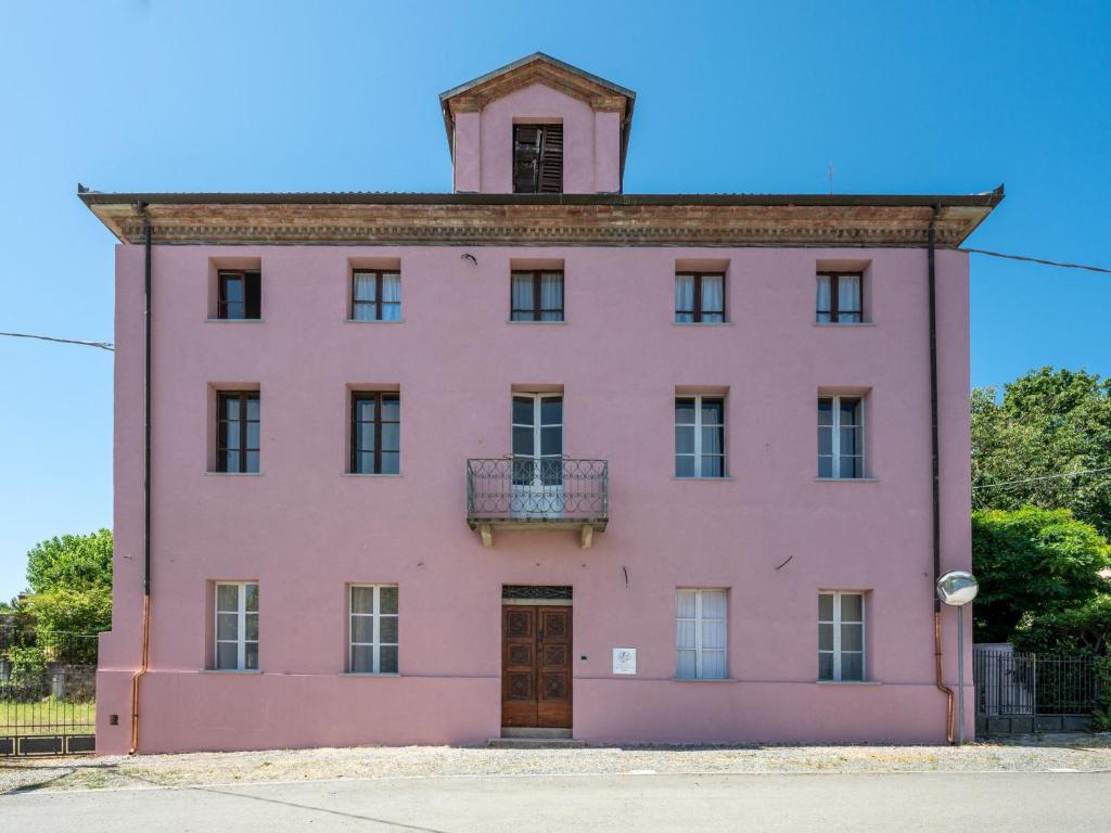 un edificio rosa con una torre dell'orologio in cima di Holiday Home Mariscotti by Interhome a SantʼAndrea