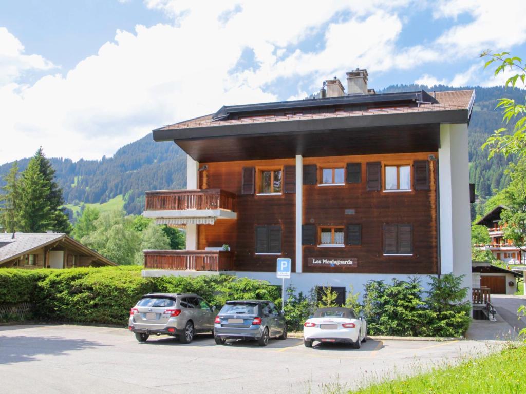 a building with cars parked in a parking lot at Apartment Montagnards 17 by Interhome in Villars-sur-Ollon