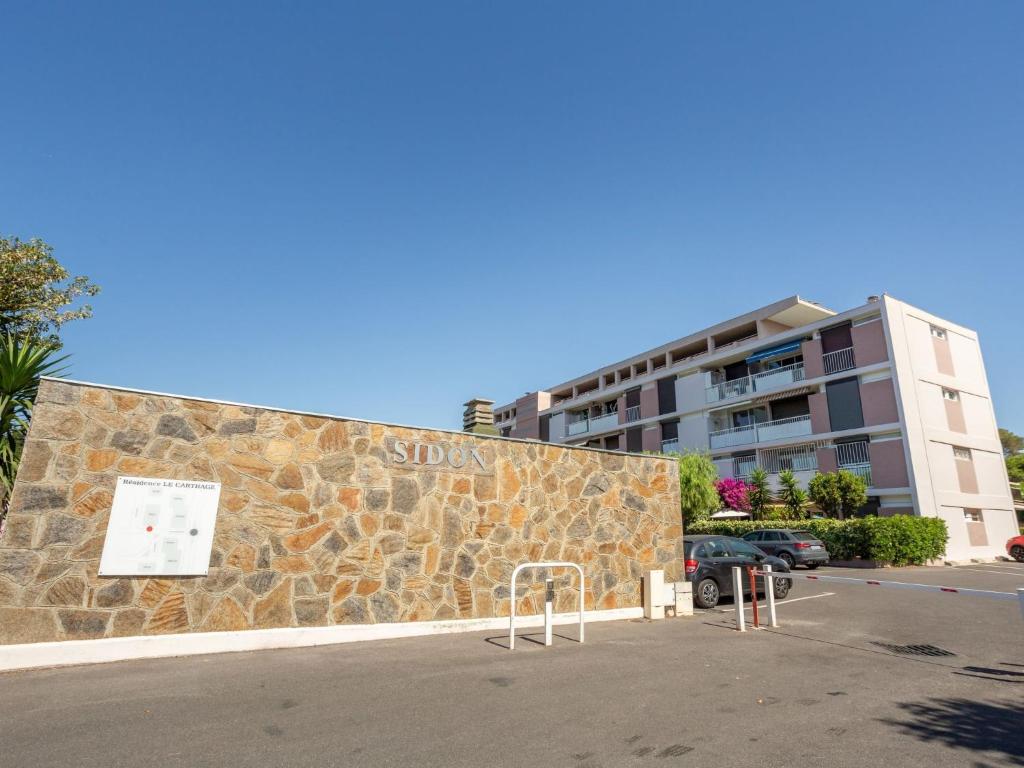 a stone wall with a sign on it next to a building at Apartment Le Carthage by Interhome in Carqueiranne