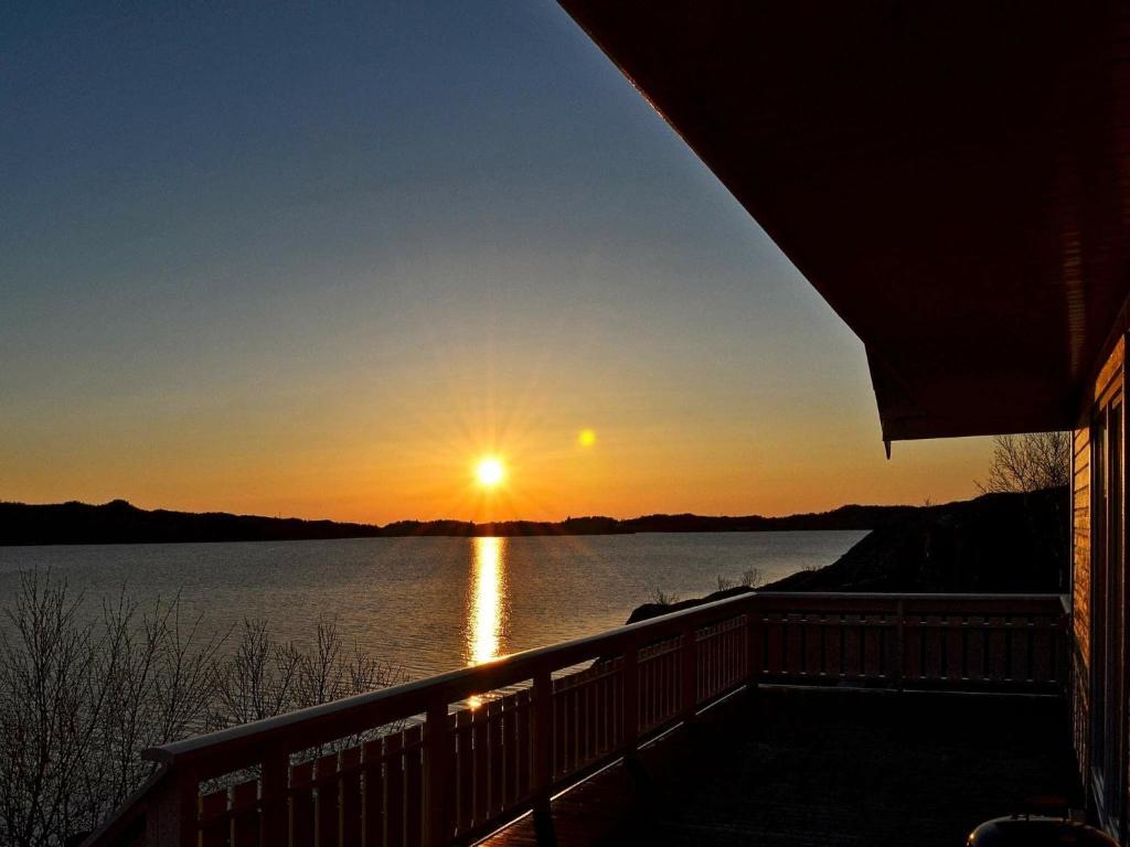 um pôr-do-sol sobre um lago com o pôr-do-sol em 5 person holiday home in Laukvik em Laukvik