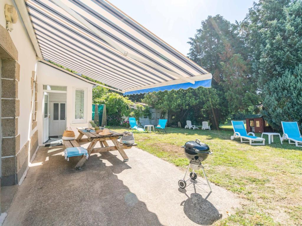 a patio with a picnic table and blue chairs at Holiday Home Ti ar Stang by Interhome in Esquibien