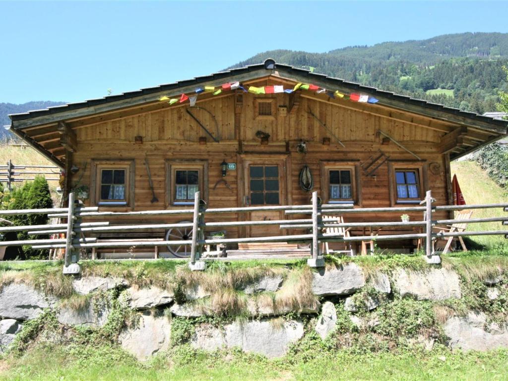 a log cabin with a fence in front of it at Holiday Home Lindenalm by Interhome in Schwendau