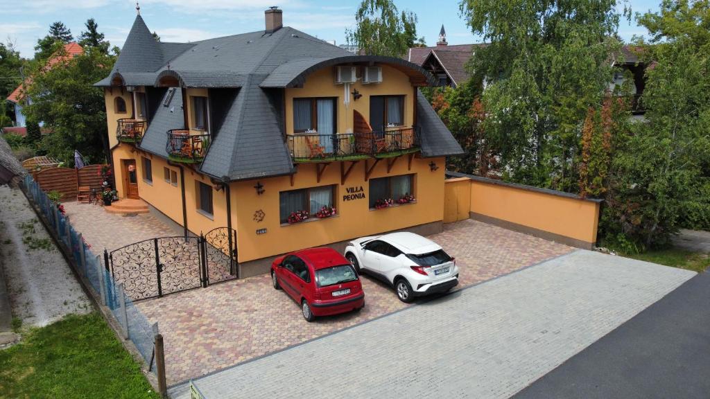 dos autos estacionados frente a una casa en Villa Peonia en Keszthely