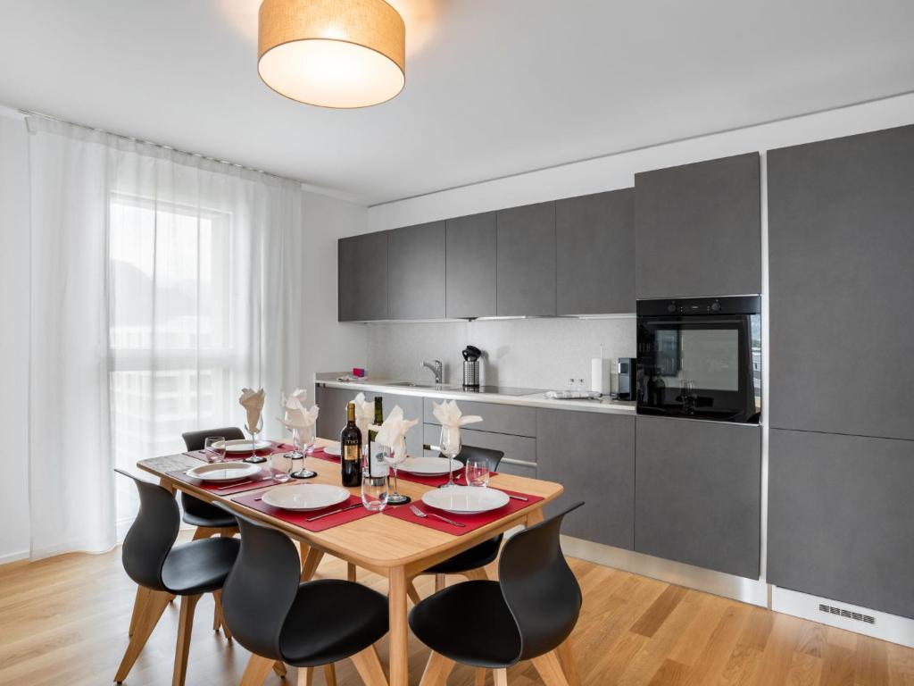 een eetkamer met een tafel en stoelen in een keuken bij Apartment LocTowers A4-8-2 by Interhome in Locarno