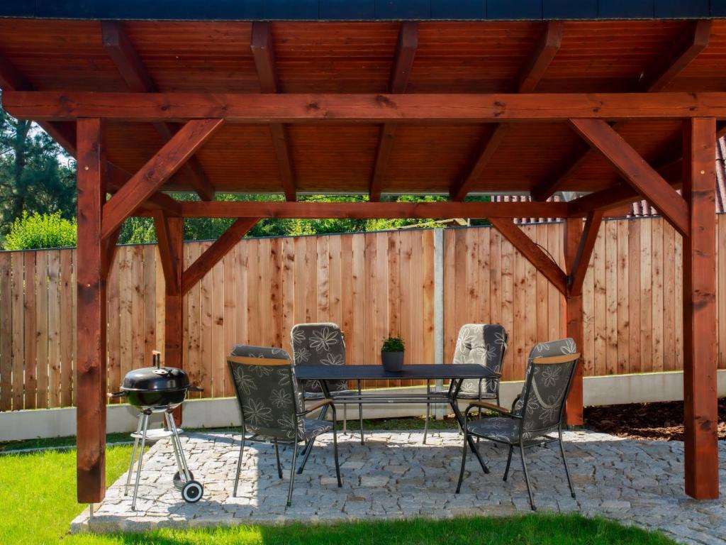 patio z grillem i krzesłami pod drewnianą pergolą w obiekcie Holiday Home Dehtáře by Interhome w mieście Hluboká nad Vltavou