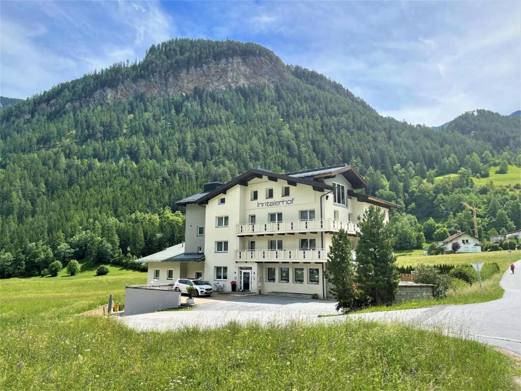 a large white house in front of a mountain at Apartment Inntalerhof-1 by Interhome in Tösens