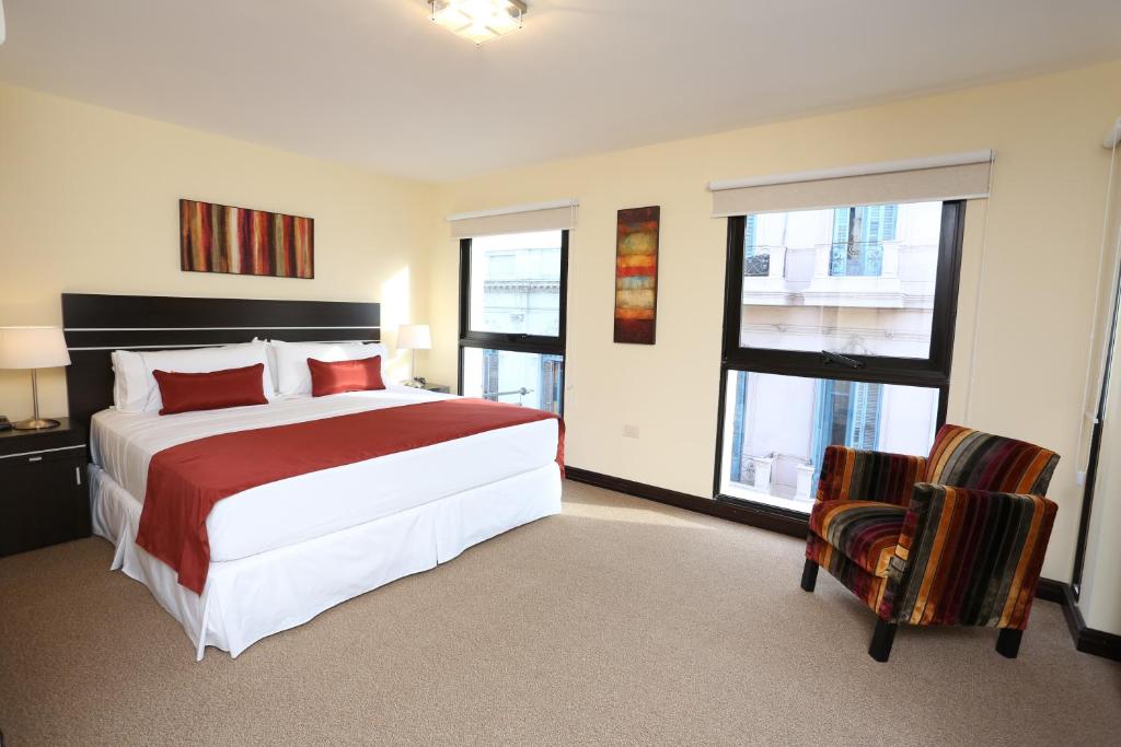 a bedroom with a large bed and two chairs at Puerto Mercado Hotel in Montevideo