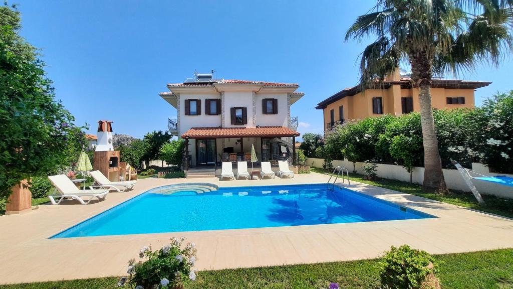 a villa with a swimming pool in front of a house at villa vaha in Ortaca